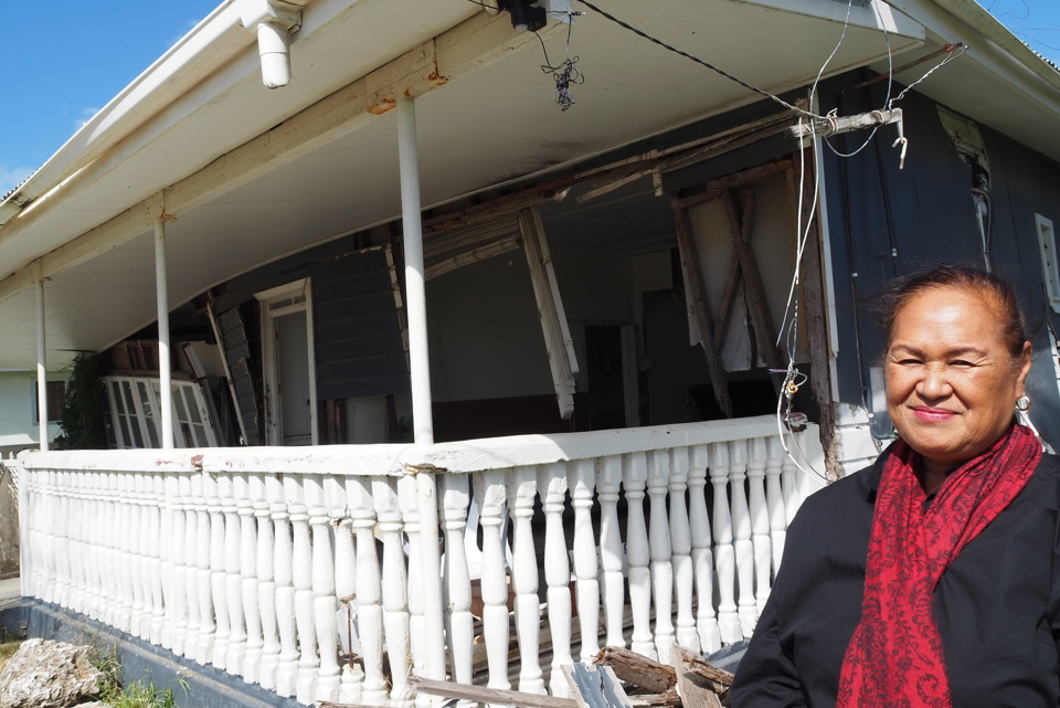 Tupou standing outside a home destroyed by the tsunami in Tonga.