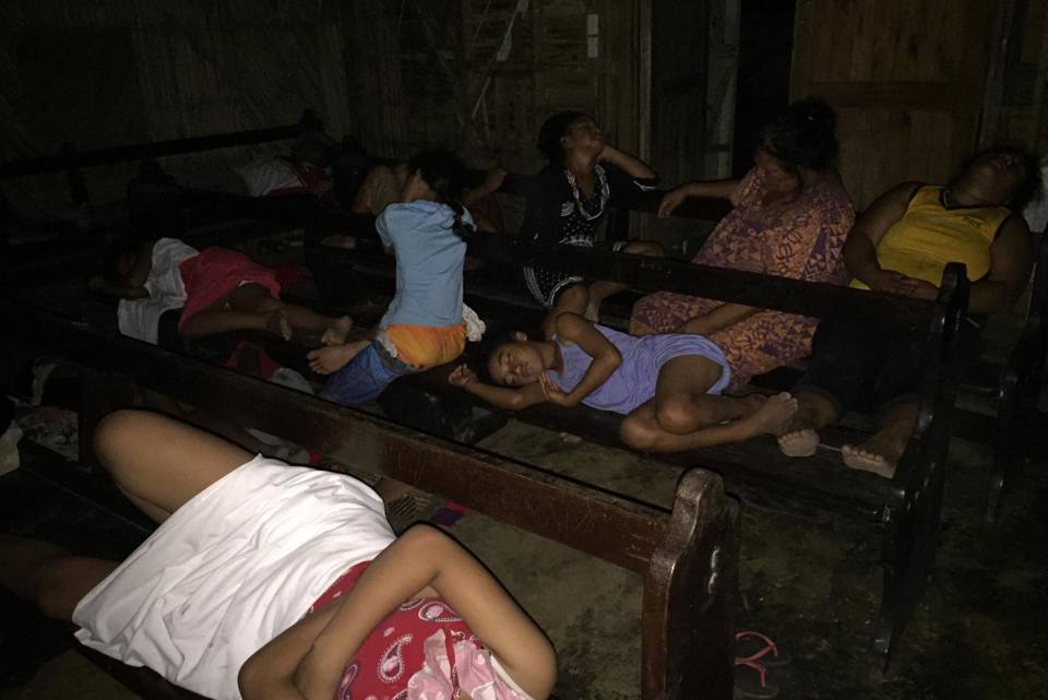 Families seek shelter inside a chapel following the volcanic eruption and tsunami in Tonga.