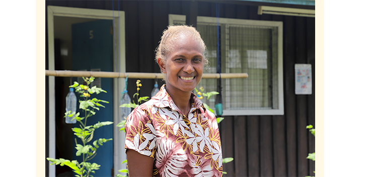 Margret standing outside a classroom in the Solomon Islands