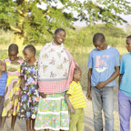 Maria standing with her family outside their home in Tanzania (1)