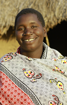 Maria standing outside of her home in Tanzania