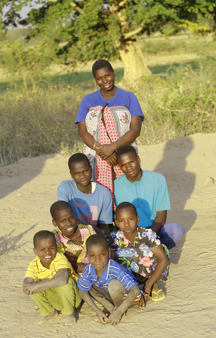 Maria with her children outside their home in Tanzania